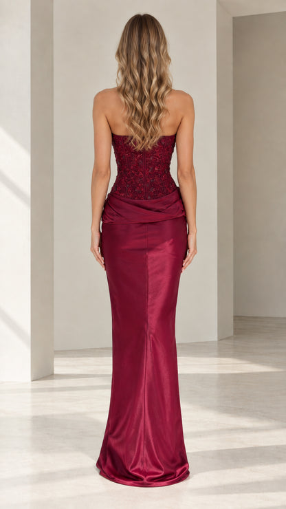 Back view of model in burgundy strapless satin formal gown