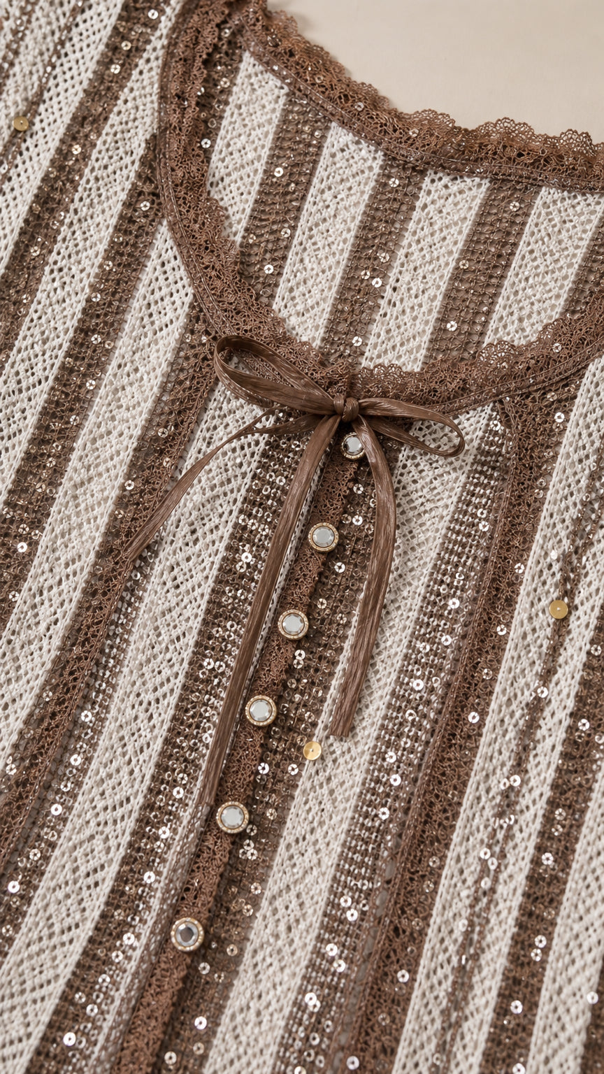 Close-up detail of the lace-trimmed neckline, ribbon tie, buttons, and sequined stripes