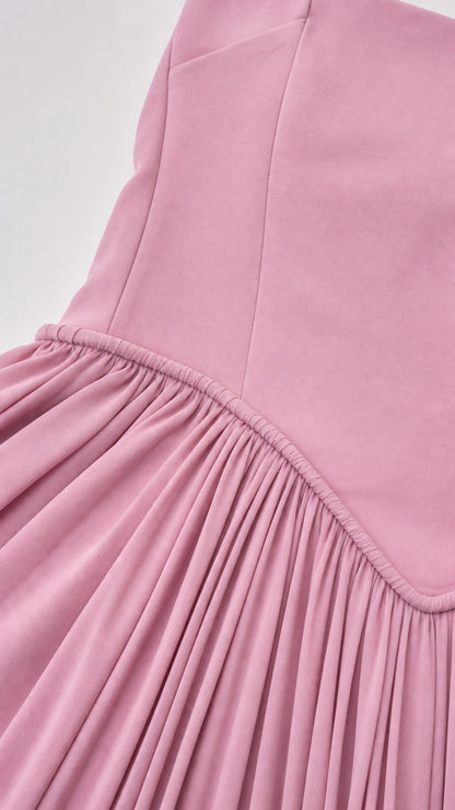 Close up detail of dusty pink drop waist seam and fine accordion pleating