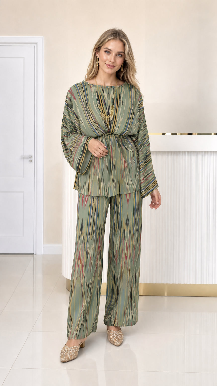 Front full view of woman wearing sage green ikat print pleated two-piece outfit